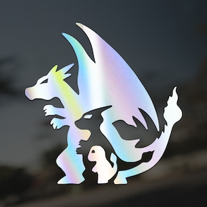 May include: A holographic vinyl sticker featuring a silhouette of three dragons. The largest dragon is in the center with its wings spread wide. A smaller dragon is nestled inside the larger dragon's wings. The smallest dragon is at the bottom of the image.