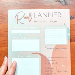 Op de afbeelding: Een roze en groene planner met de titel "Reel Planner" en secties voor het plannen van een reel, waaronder "Categorie van inhoud", "Materiaal van de scène", "Kopie/bijschrift", "Hashtags en tags", "Ideeën voor overgangen", "Kop of initiële hook", "Muziek of trend", "Effecten", "Voiceover", "Opnemen", "Bewerken", "Ondertitels", "Publiceren" en "Resultaten".