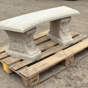 May include: A light grey concrete garden bench featuring a rectangular seat with a decorative border pattern and two sturdy, ornate pedestal legs with carved scrollwork and leaf motifs, providing a stable base for outdoor seating arrangements.