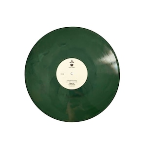 Könnte beinhalten: Eine dunkelgrüne Schallplatte mit einem weißen Label. Das Label zeigt ein kleines Pflanzen-Symbol und den Text "Liquid Robot" und "Side A". Die Platte enthält die folgenden Songtitel: "Gathering Around", "Put Him For The Hole", "Dead Up", "Construction", "Overhear".