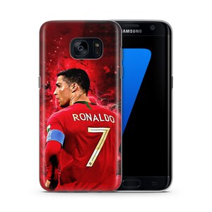 May include: A red, white, and gold phone case with a picture of Cristiano Ronaldo wearing a red soccer jersey with the number 7 on the back. The text "RONALDO" is printed above the number. The case is designed for a Samsung Galaxy S7 Edge.