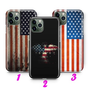 Op de afbeelding: Drie verschillende iPhone-hoesjes met Amerikaanse vlagontwerpen. De eerste hoes heeft een verweerde houtnerf-achtergrond met een Amerikaanse vlag eroverheen. De tweede hoes heeft een zwarte achtergrond met een gestileerd Amerikaans vlaggen-adelaarontwerp. De derde hoes heeft een verweerd Amerikaans vlagontwerp.