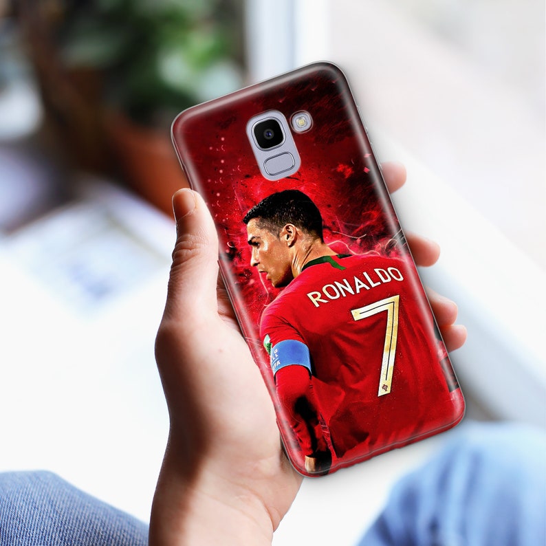 K&ouml;nnte beinhalten: Eine rote, wei&szlig;e und gr&uuml;ne Handyh&uuml;lle mit einem Bild eines Fu&szlig;ballspielers, der ein rotes Trikot mit der Nummer 7 und dem Namen "RONALDO" auf dem R&uuml;cken tr&auml;gt.