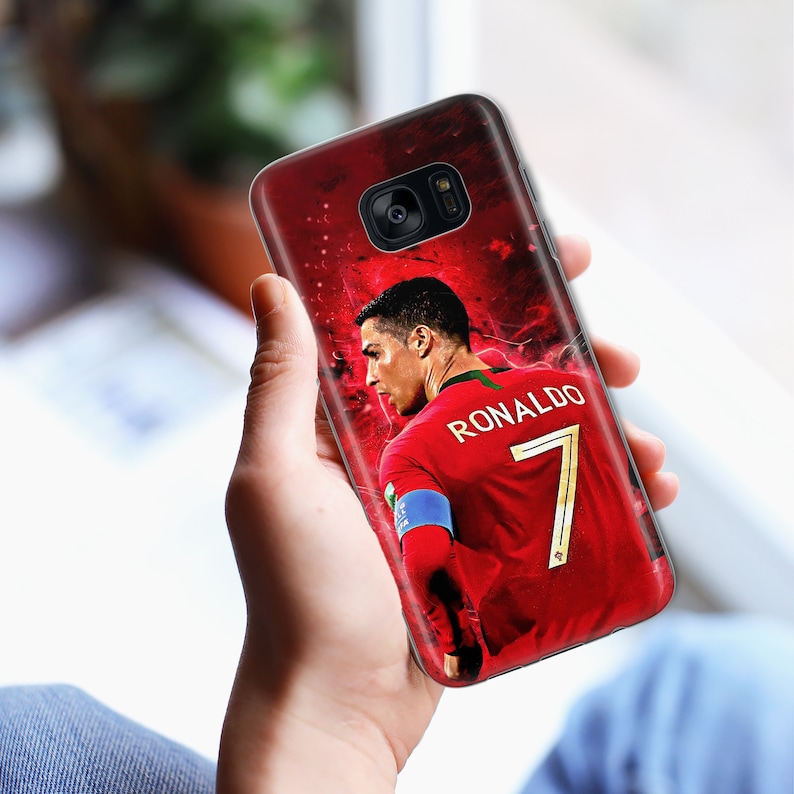 May include: A red, white, and green phone case with a picture of a soccer player wearing a red jersey with the number 7 and the name "RONALDO" on the back.