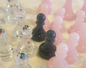 Juego de 16 piezas de ajedrez de resina en color carbón, rosa o transparente con estrellas.
