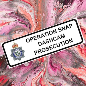 Puede incluir: Un letrero rectangular blanco con texto negro que dice "OPERATION SNAP DASHCAM PROSECUTION" sobre un fondo abstracto y colorido. El letrero también presenta el escudo de la Policía de Lincolnshire. El fondo es una mezcla de rosa, rojo y blanco.