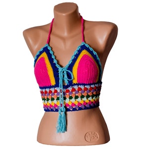 May include: A colorful crocheted halter top with a blue, pink, yellow, and green color scheme. The top has a tassel detail and a tie closure at the neck.