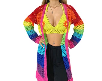 May include: A rainbow crochet cardigan with a long, open front. The cardigan is made of a lightweight, airy yarn and features a colorful striped pattern.