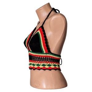 May include: A black crochet halter top with red, green, and yellow stripes. The top has a crocheted design and is made of a soft, lightweight material.