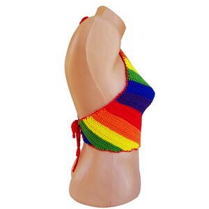 May include: A rainbow crochet halter top with a tie closure in the back. The top is made with a variety of colors, including red, orange, yellow, green, blue, and purple.