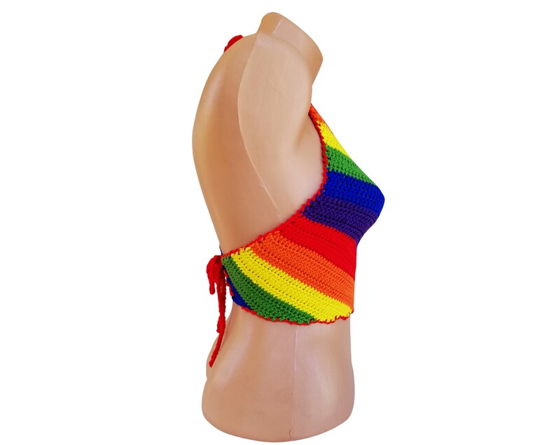 May include: A rainbow crochet halter top with a tie closure in the back. The top is made with a variety of colors, including red, orange, yellow, green, blue, and purple.