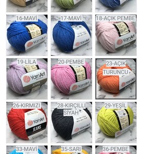 May include: A collection of 12 yarn balls in various colors, including white, cream, beige, light green, light blue, blue, lilac, pink, orange, red, yellow, and gray. Each ball is labeled with a number and a color name in Turkish. The yarn is labeled "YarnArt Jeans".
