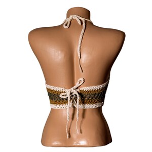 May include: A crocheted halter top with a white and brown striped pattern. The top is tied at the back with white strings.