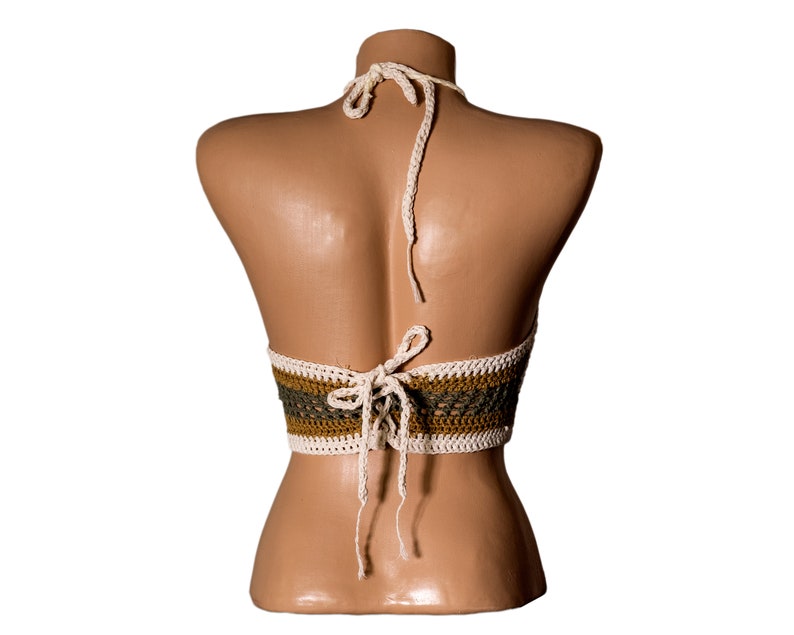 May include: A crocheted halter top with a white and brown striped pattern. The top is tied at the back with white strings.