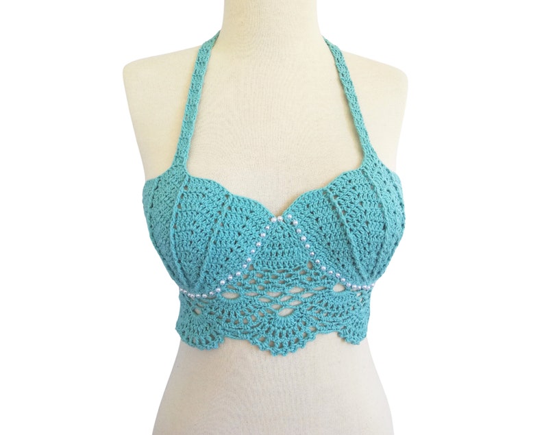 May include: A teal blue crochet halter top with a scalloped hem and silver bead embellishments.
