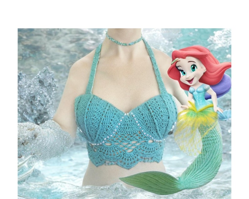 May include: A teal crochet top with a mermaid tail and a cartoon mermaid illustration. The top has a scalloped edge and is decorated with small, sparkly beads.