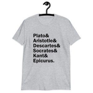Puede incluir: Camiseta gris con texto negro que dice "Plato & Arist&oacute;teles & Descartes & S&oacute;crates & Kant & Epicuro."
