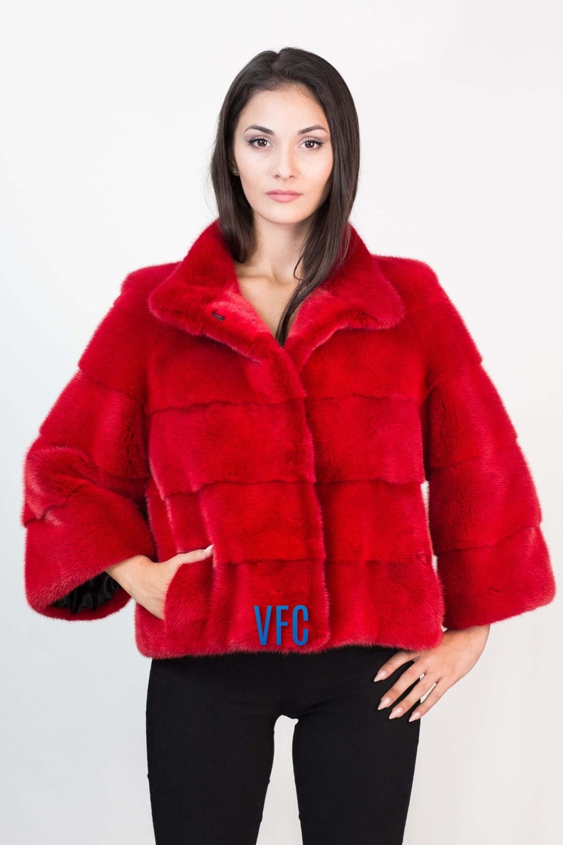 Peut inclure: Une veste en fourrure rouge avec un logo VFC sur le devant. La veste a un col et une fermeture &eacute;clair.