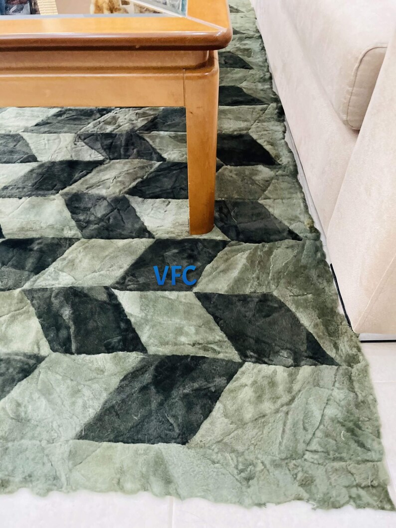 Puede incluir: Una alfombra de patr&oacute;n geom&eacute;trico verde y negro con una mesa de caf&eacute; de madera en la parte superior. La alfombra tiene una textura peluda.