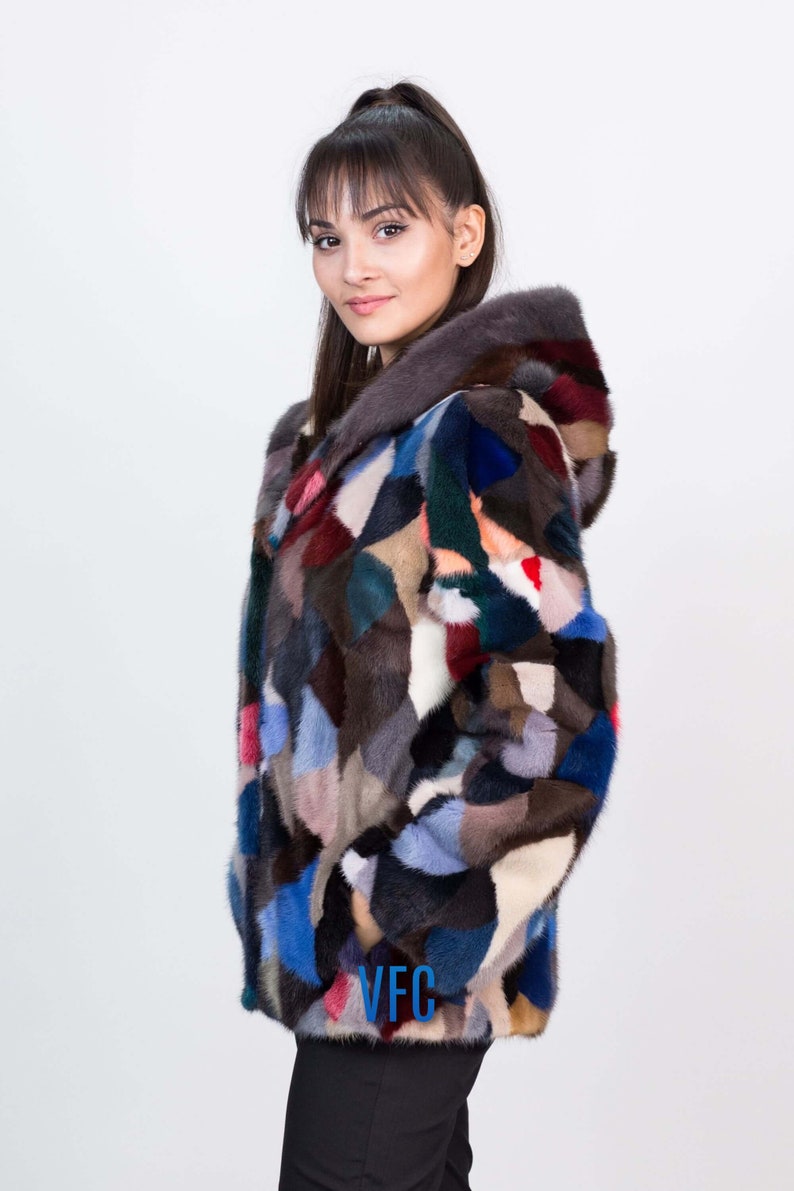 Puede incluir: Una chaqueta de piel de patchwork colorida con capucha. La chaqueta est&aacute; hecha de pieles de diferentes colores, incluyendo azul, rojo, verde y marr&oacute;n. La chaqueta tiene un logotipo de VFC en la parte inferior.