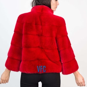 Peut inclure: Une veste en fourrure rouge avec un logo VFC au dos.