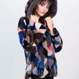 Puede incluir: Una chaqueta de piel de patchwork colorida con capucha. La chaqueta est&aacute; hecha de piezas de piel de diferentes colores, incluyendo azul, marr&oacute;n, rosa y blanco. La chaqueta tiene un logotipo de VFC en la parte delantera.