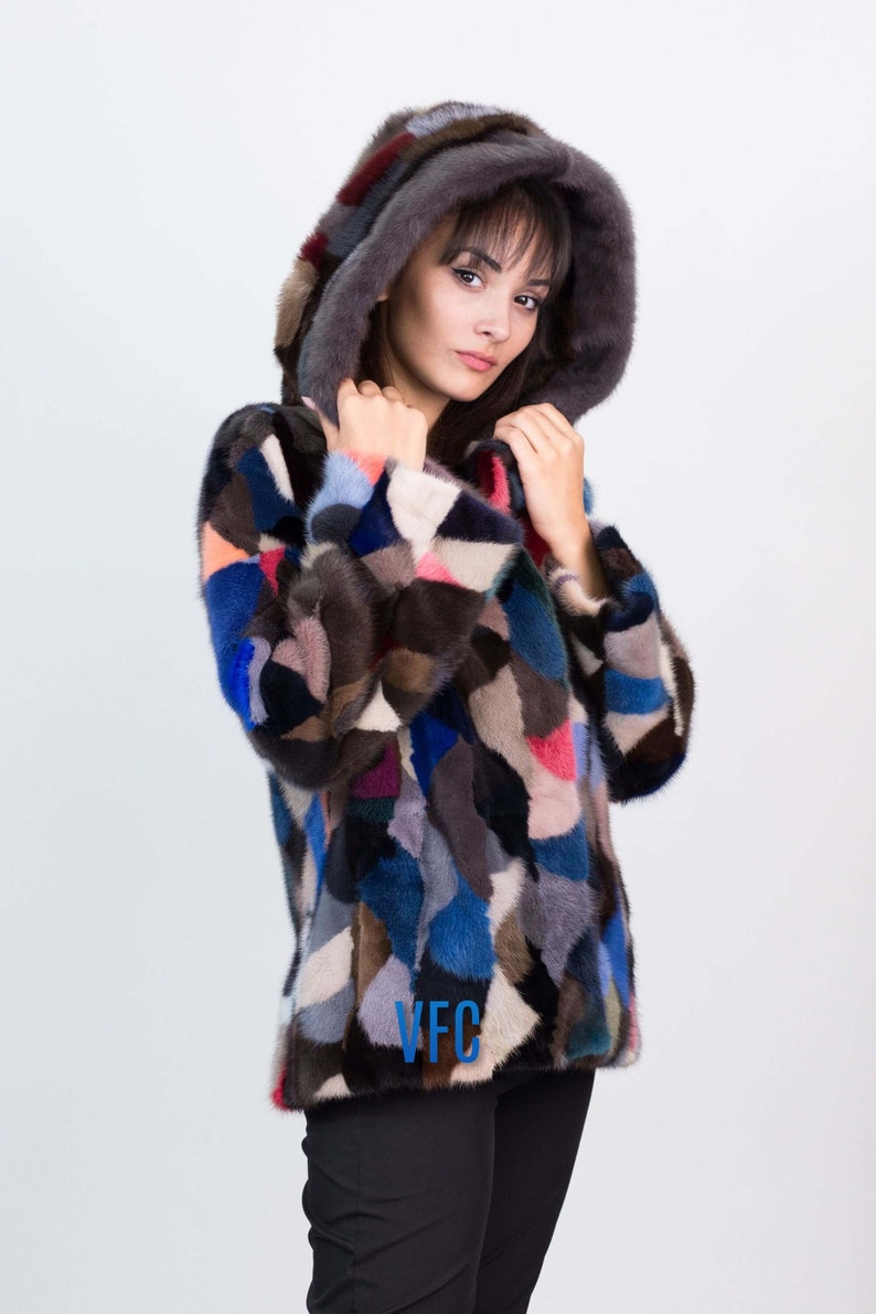 Puede incluir: Una chaqueta de piel de patchwork colorida con capucha. La chaqueta est&aacute; hecha de piezas de piel de diferentes colores, incluyendo azul, marr&oacute;n, rosa y blanco. La chaqueta tiene un logotipo de VFC en la parte delantera.