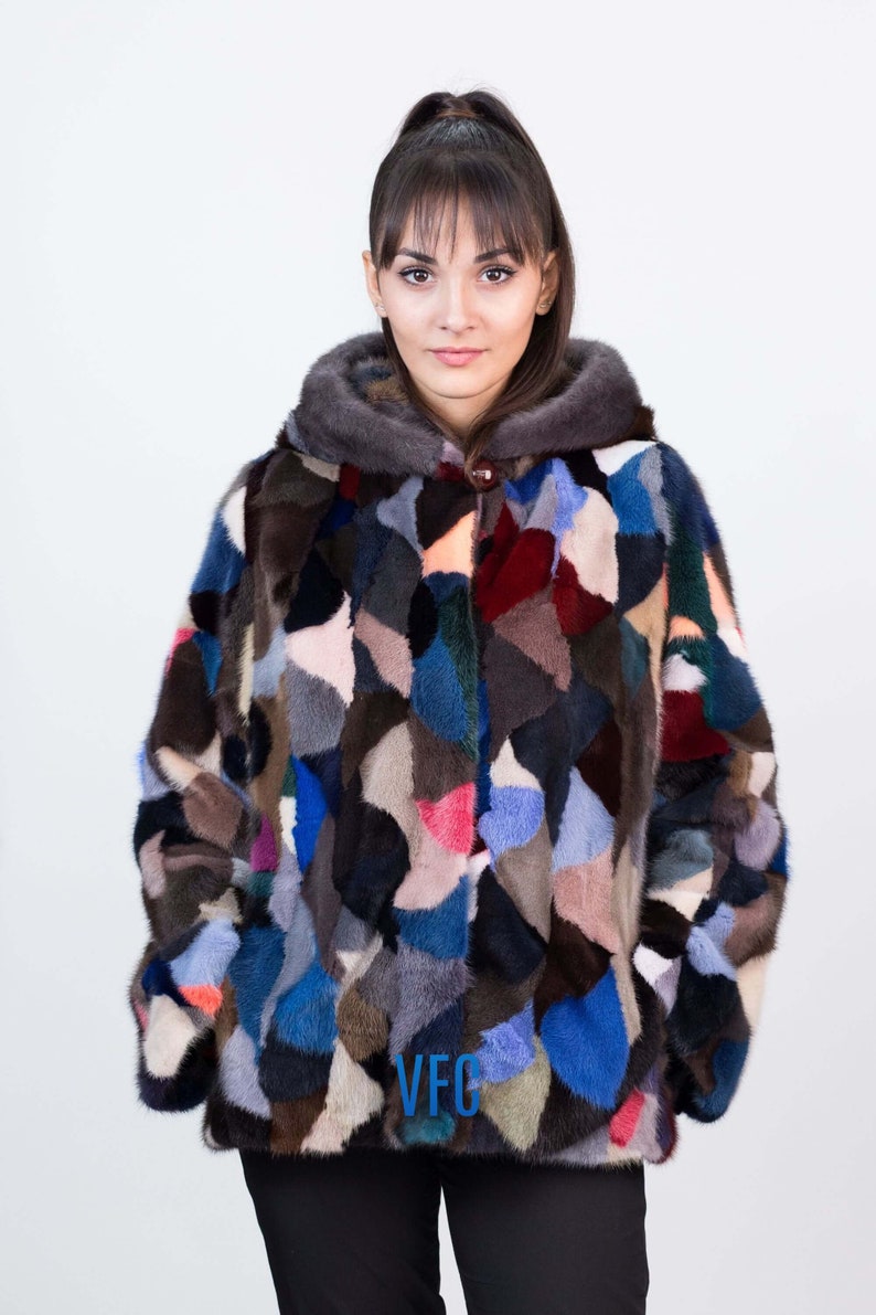 Puede incluir: Una chaqueta de piel de patchwork colorida con capucha. La chaqueta est&aacute; hecha de diferentes piezas de piel de colores cosidas juntas en un patr&oacute;n geom&eacute;trico. La chaqueta tiene un cierre de bot&oacute;n y un logotipo VFG en la parte delantera.
