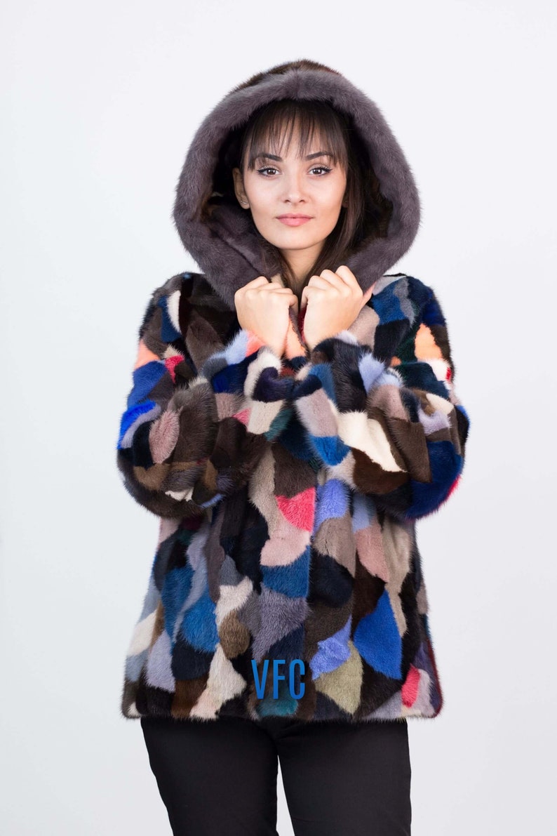 Puede incluir: Una chaqueta de piel de patchwork colorida con capucha. La chaqueta est&aacute; hecha de pieles de diferentes colores, incluyendo marr&oacute;n, negro, azul y rosa. La chaqueta tiene un logotipo de VFC en la parte delantera.