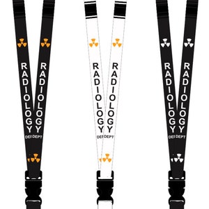 Peut inclure: Trois lanyards noirs et blancs avec un clip noir et un crochet argenté. Les lanyards ont un motif répété d'un symbole de radiation et le texte "RADIOLOGY DEF DEPT".