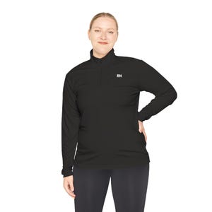 May include: Black long-sleeve shirt with a mock neck and a zipper. The shirt has the letters "RN" embroidered on the chest.