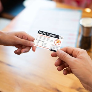May include: A white card with black text that reads "Celiac Disease I cannot eat gluten" and a red circle with a diagonal line through a wheat stalk. The card also includes a list of ingredients that contain gluten. The card is being passed from one person to another.