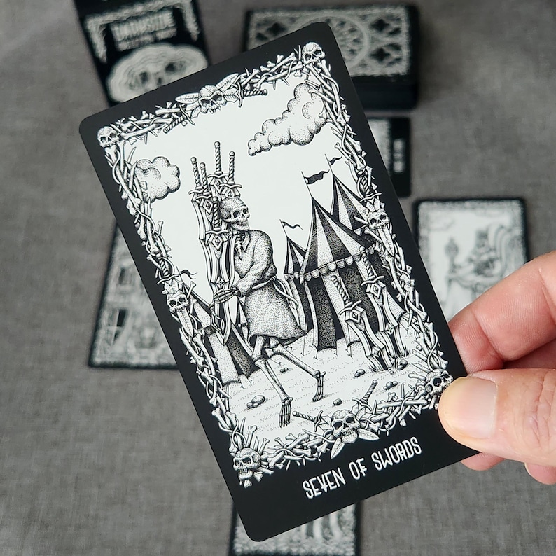 May include: Black and white tarot card illustration of the Seven of Swords. A skeletal figure is running away with seven swords, leaving behind a tent and other swords.