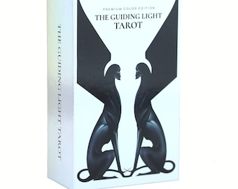 May include: A tarot card box with the title "THE GUIDING LIGHT TAROT" in black text. The box features a black illustration of two figures with wings facing each other. The box is white with a pearlescent sheen.
