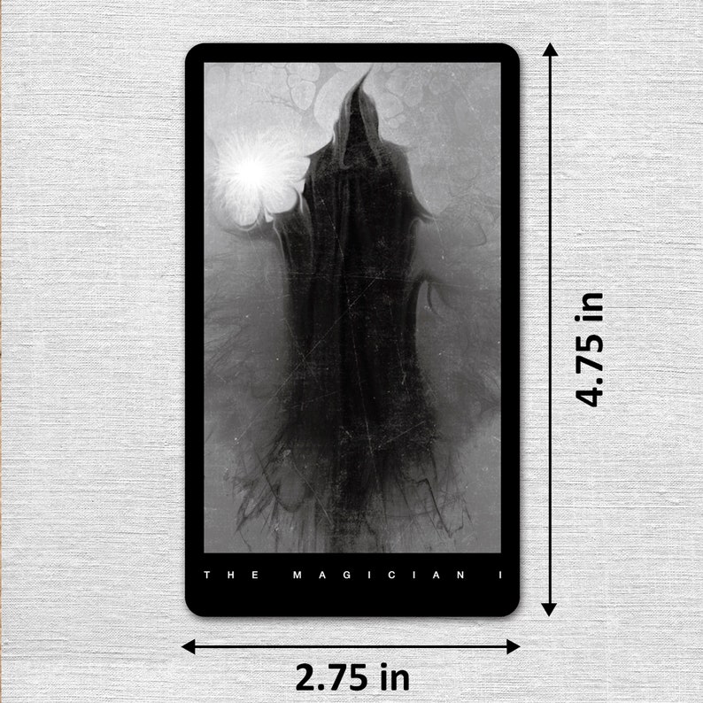 May include: Black and white tarot card featuring a hooded figure with a glowing orb in the background. The card is titled "The Magician". The card measures 4.75 inches by 2.75 inches.