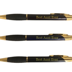 May include: Three black and gold pens with the text "Best Aunt Ever" in gold lettering. The pens have a black rubber grip and gold accents on the tip and clip. The pens are displayed on a white background.