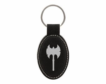 May include: Black leather keychain with a silver axe design. The keychain has a silver metal ring.