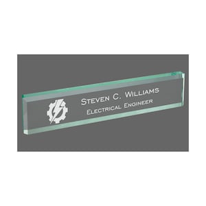 May include: A clear green glass desk nameplate with a white gear and lightning bolt design. The nameplate reads "STEVEN C. WILLIAMS ELECTRICAL ENGINEER".