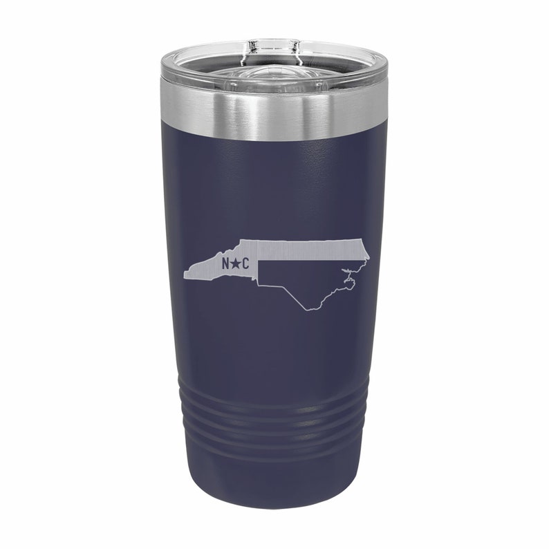 Pu&ograve; includere: Un bicchiere in acciaio inossidabile blu navy con un contorno bianco dello stato della Carolina del Nord e il testo "N*C" sul lato.