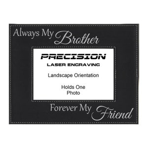 May include: Black leather picture frame with the text "Always My Brother" and "Forever My Friend" engraved in silver. The frame is designed to hold one photo in landscape orientation. The frame is made by Precision Laser Engraving.
