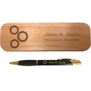 May include: A wooden desk nameplate with a laser engraved design of three gears and the text "JOHN W. SMITH MECHANICAL ENGINEER". A black pen with gold accents and the text "John W. Smith" is also included.