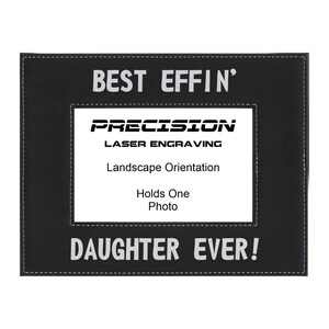 May include: Black leather picture frame with white stitching. The frame has a white inscription that reads "Best Effin' Daughter Ever!" and a white logo that reads "Precision Laser Engraving".