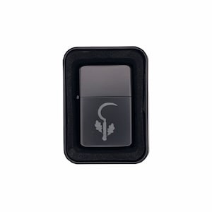 May include: A black lighter with a silver design of a sickle and leaves. The lighter is in a black box.