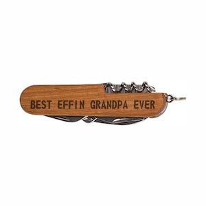 May include: A wooden handled multi-tool with a corkscrew, a saw, a knife, and a bottle opener. The handle is engraved with the text "BEST EFFIN GRANDPA EVER".