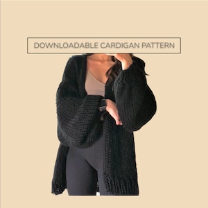 Puede incluir: Un cárdigan negro de punto grueso con mangas largas y voluminosas. El suéter abierto se muestra en una persona. El texto "DOWNLOADABLE CARDIGAN PATTERN" se muestra en un cuadro blanco encima del cárdigan.