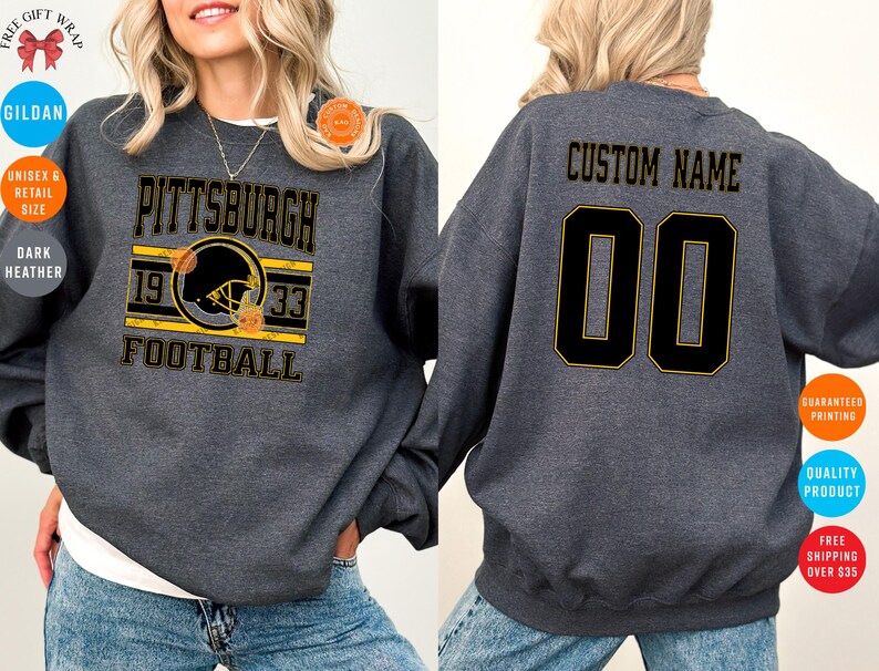 May include: Dark heather gray sweatshirt with "PITTSBURGH FOOTBALL" text and a football helmet graphic in black and yellow. The back features "CUSTOM NAME" and the number "00" in black with yellow trim.