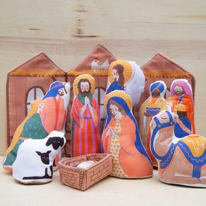 May include: A felt nativity set with a brown stable, a white sheep, a camel, and figures of Mary, Joseph, and the three wise men.
