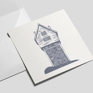 May include: A white envelope with a square card inside. The card features a blue line drawing of a tall, narrow house with a pointed roof.