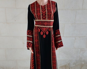 Robe palestinienne Thobe Tatreez noire et rouge avec des lignes dorées.