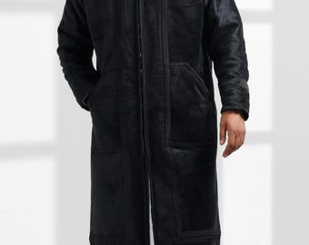 May include: A long black hooded jacket with a zipper closure and decorative stitching. The jacket has two pockets on the front and a drawstring hood.